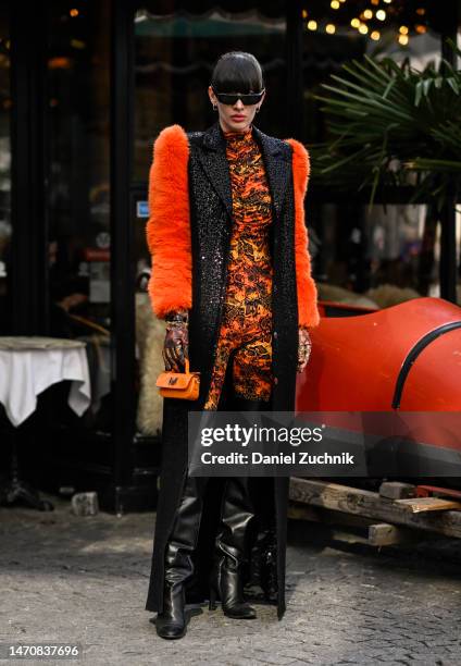 Katya Tolstova is seen wearing a Marcell von Berlin sequin coat with faux fur sleeves, printed jumpsuit, Pinko thigh-high boots and Prada sungalsses...