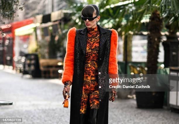 Katya Tolstova is seen wearing a Marcell von Berlin sequin coat with faux fur sleeves, printed jumpsuit, Pinko thigh-high boots and Prada sungalsses...