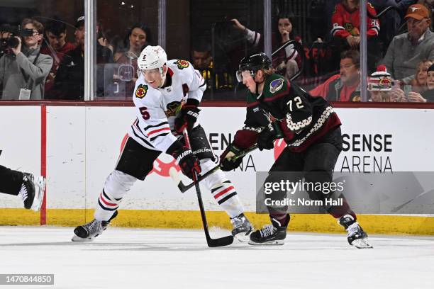 Connor Murphy of the Chicago Blackhawks battles for position with Travis Boyd of the Arizona Coyotes at Mullett Arena on February 28, 2023 in Tempe,...