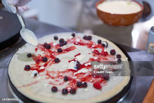 cooking a french crepe, pancake in a pan with mixed berry and cream - maslenitsa stock pictures, royalty-free photos & images