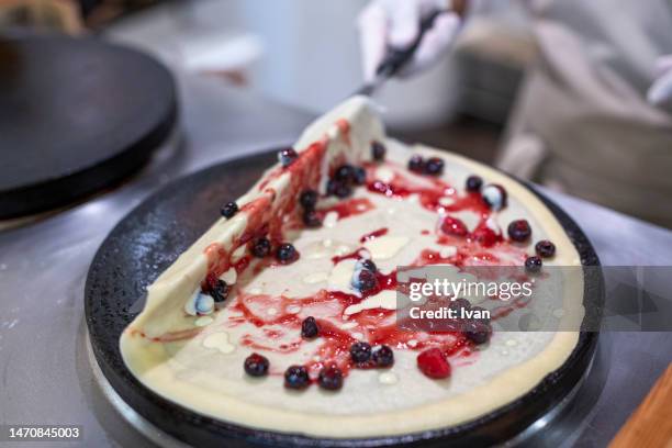 cooking a french crepe, pancake in a pan with mixed berry and cream - maslenitsa stock pictures, royalty-free photos & images