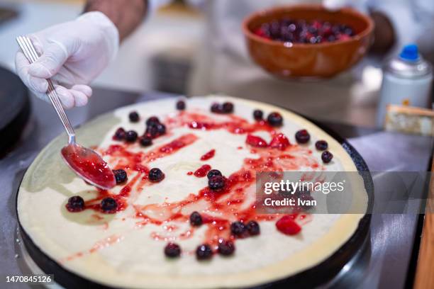 cooking a french crepe, pancake in a pan with mixed berry and cream - maslenitsa stock pictures, royalty-free photos & images