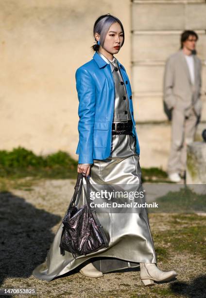 Guest is seen wearing a light blue jacket, silver top, silver skirt, silver bag and cream boots outside the Givenchy show during Paris Fashion Week...