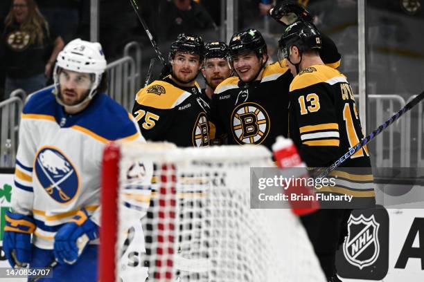 Jakub Lauko of the Boston Bruins celebrates with Connor Clifton, Charlie Coyle, and Matt Grzelcyk after scoring a goal against the Buffalo Sabres...