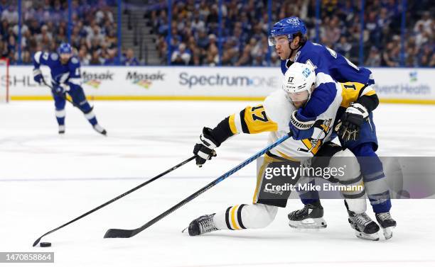 Bryan Rust of the Pittsburgh Penguins and Brayden Point of the Tampa Bay Lightning fight for the puck in the third period during a game at Amalie...