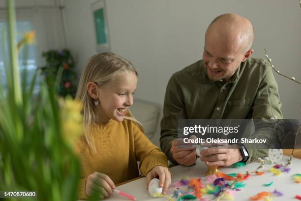 dad and his daughter with bunny ears decorate eggs for easter - easter bunny mask fotografías e imágenes de stock