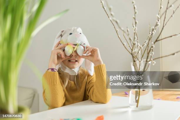 girl with bunny ears covered her eyes with eggs for easter - easter bunny mask imagens e fotografias de stock
