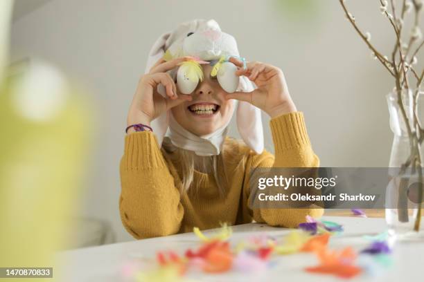 girl with bunny ears covered her eyes with eggs for easter - easter bunny mask fotografías e imágenes de stock