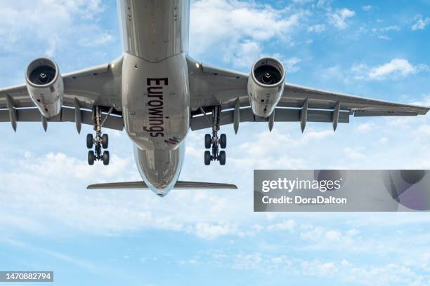 airplane landing on runway in pearson international airport at dusk, toronto,canada - eurowings luftverkehrs ag stock pictures, royalty-free photos & images