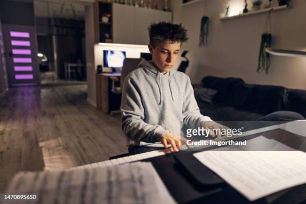 teenage boy practicing piano at home - pianist front stock pictures, royalty-free photos & images