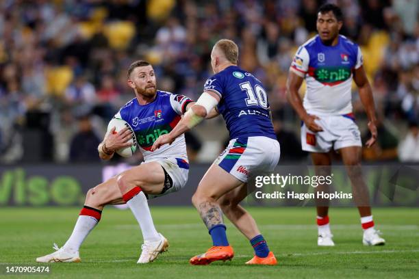 Jackson Hastings of the Knights fends off Mitchell Barnett of the Warriors during the round one NRL match between the New Zealand Warriors and...