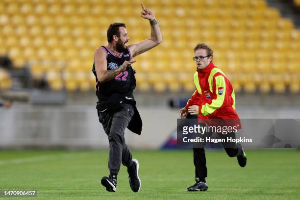 Pitch invader is chased down by security during the round one NRL match between the New Zealand Warriors and Newcastle Knights at Sky Stadium on...
