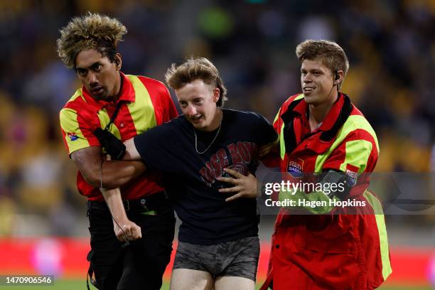 Pitch invader is taken off by security during the round one NRL match between the New Zealand Warriors and Newcastle Knights at Sky Stadium on March...