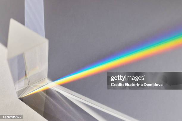 light passes through a glass prism on a white background - lumières photos et images de collection