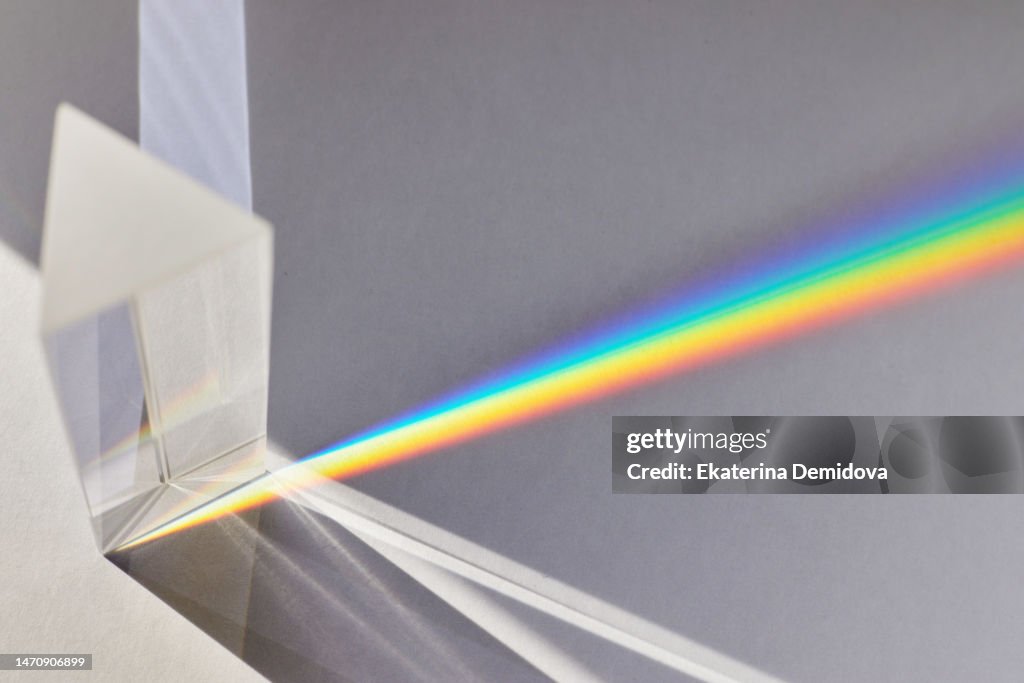 Light passes through a glass prism on a white background