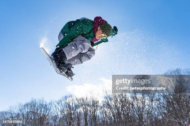 snowboarder doing a jump on a sunny day - snowboard jump close up stock pictures, royalty-free photos & images