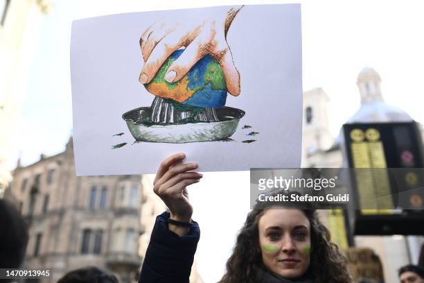 Protesters hold signs and banners during a climate strike on March 3, 2023 in Turin, Italy. Young climate activists are expected to walk out of...