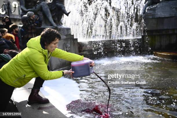 Protester throws red paint into a fountain during a climate strike on March 3, 2023 in Turin, Italy. Young climate activists are expected to walk out...