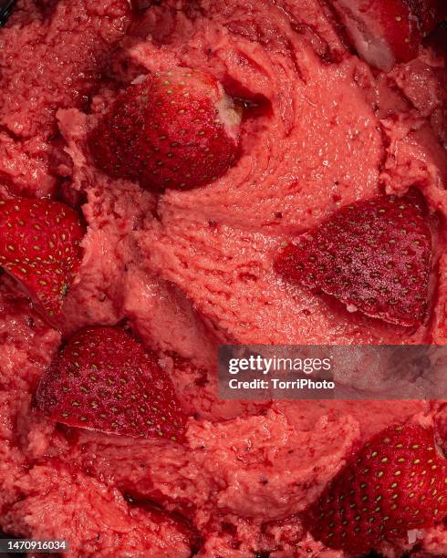 full frame creamy texture background of strawberry sorbet ice cream with strawberry pieces - aardbeienijs stockfoto's en -beelden