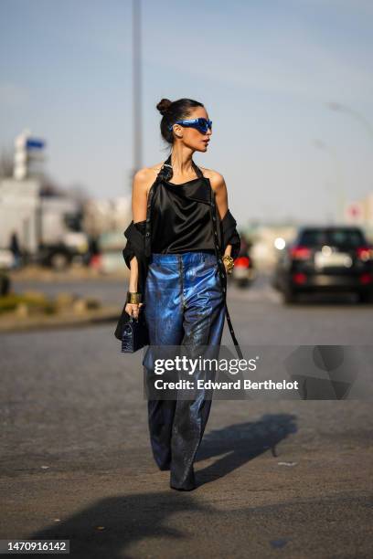 Heart Evangelista wears royal blue metallic puffy sunglasses from Off-White, diamonds earrings, a black silk with halter belt neck / backless...