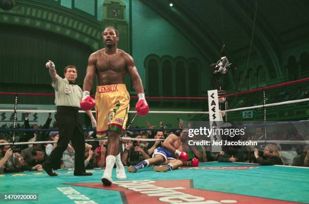 Referee Frank Cappuccino instructs Lennox Lewis from Great Britain to walk to a neutral corner as Shannon Briggs from the United States lays on the...