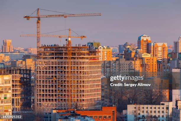 an urban skyline in the background against constructing skyscrapers dominating the aerial cityscape - russia skyline stock pictures, royalty-free photos & images