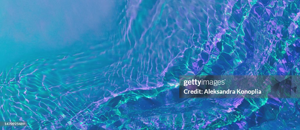 Banner with ethereal holographic dark blue, purple, pink, turquoise, mint green transparent water surface texture with ripples, splashes, waves