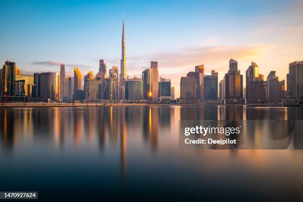 long exposure of the business bay dubai city skyline at twilight, united arab emirates - dubai stockfoto's en -beelden