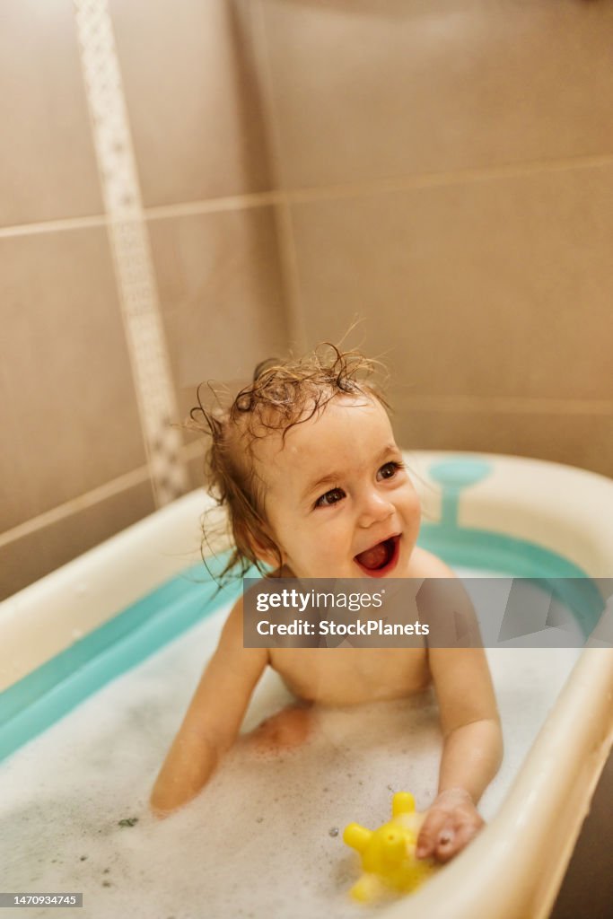 Lindo bebé divirtiéndose en el tubo de baño