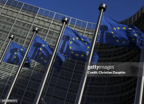 european union flags waving at berlaymont building of the european commission - außenpolitik stock-fotos und bilder