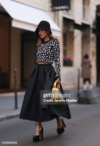 Füsun Lindner seen wearing COS black knit bucket hat, Louis Vuitton silver / gold earrings, Louis Vuitton x Yayoi Kusama black with white polka dots...