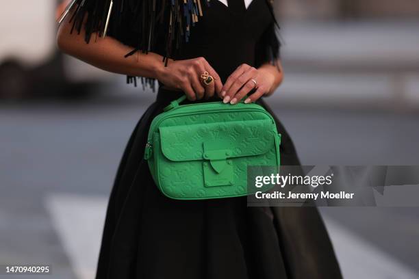 Füsun Lindner seen wearing MyBestfriends black corset, white button shirt, black tie, Alexander McQueen black pleated long skirt, Louis Vuitton green...