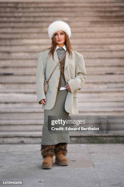 Guest wears a white fur hat, a white shirt, a khaki gray wool pullover, a matching khaki gray wool long tube skirt, a beige oversized blazer jacket,...