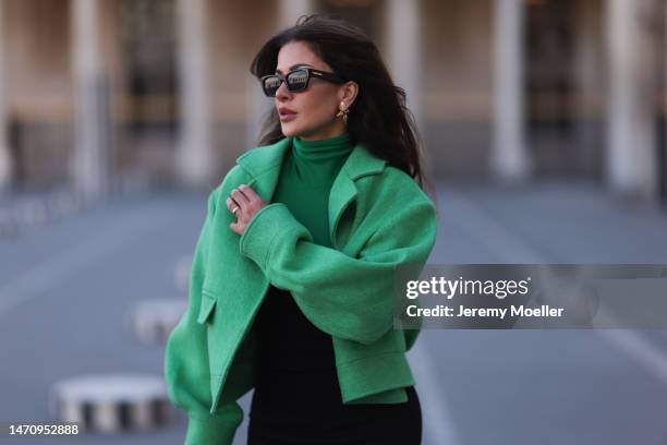 Füsun Lindner seen wearing Bottega Veneta black sunglasses, Louis Vuitton earrings, Wolford black bandeau / sleeveless jumpsuit, COS green turtleneck...