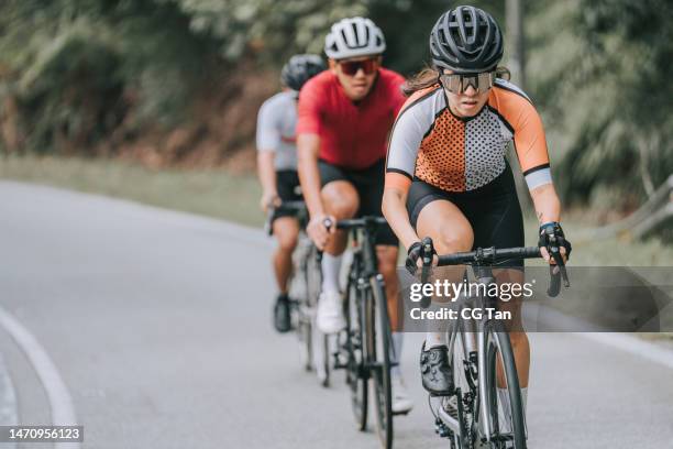 asian chinese female cyclist leading in road cycling racing - cycling team stock pictures, royalty-free photos & images