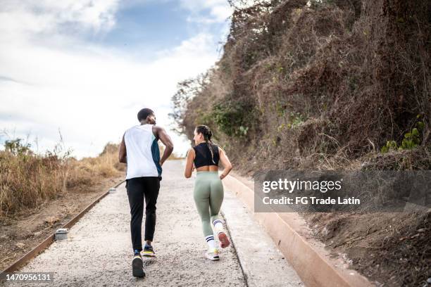 friends running together outdoors - couple running back stock pictures, royalty-free photos & images