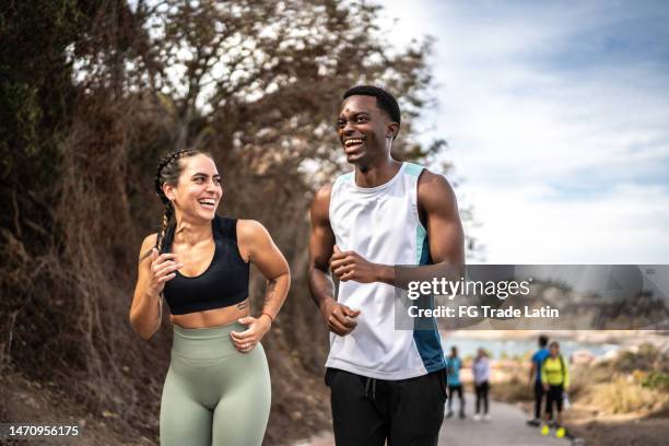 friends talking while running outdoors - couple exercising 30s stock pictures, royalty-free photos & images