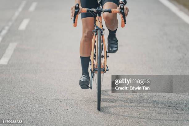 asiatisch-chinesischer radfahrer mit niedrigem winkel auf der straße mit schatten - wade menschliches körperteil stock-fotos und bilder