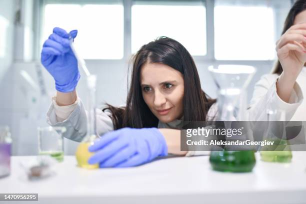 équipement de laboratoire moderne utilisé par une femme chimiste travaillant dans l’industrie pharmaceutique - flacon compte gouttes photos et images de collection