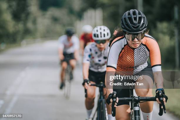 asiatisch-chinesische radrennfahrerin führt bei radrennen - führender rennsport stock-fotos und bilder