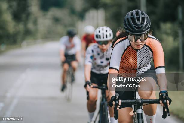 asian chinese female cyclist leading during cycling event - cycling team stock pictures, royalty-free photos & images