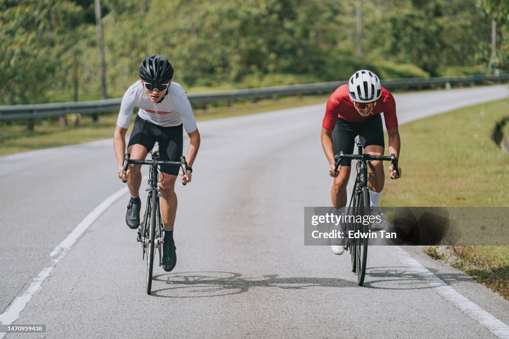 2 ciclistas masculinos chinos asiáticos compitiendo entre sí en la escena rural del evento de ciclismo