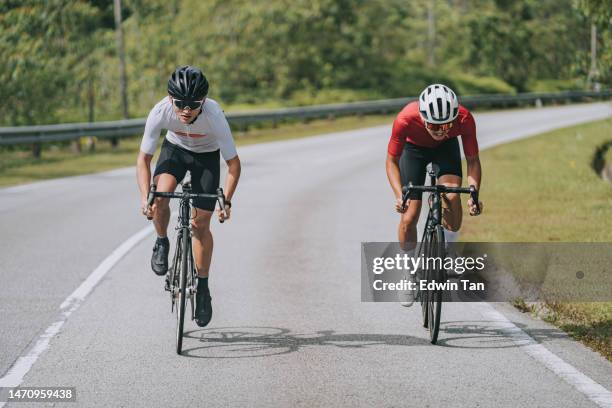 2 ciclistas masculinos chinos asiáticos compitiendo entre sí en la escena rural del evento de ciclismo - evento de ciclismo fotografías e imágenes de stock