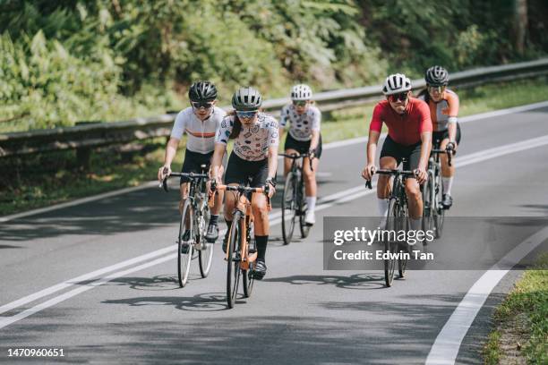asian chinese female cyclist leading in rural cycling event - cycling team stock pictures, royalty-free photos & images