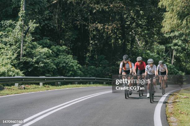 asian chinese female cyclist leading in rural cycling event - cycling team stock pictures, royalty-free photos & images
