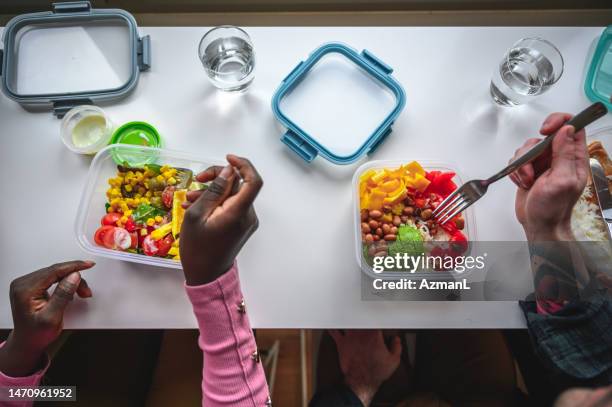 high angle shot of young woman and mid adult man eating healthy - tupperware stock pictures, royalty-free photos & images