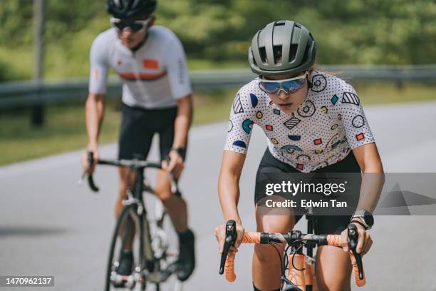 asian chinese female cyclist leading in rural cycling event - race leader athlete stock pictures, royalty-free photos & images
