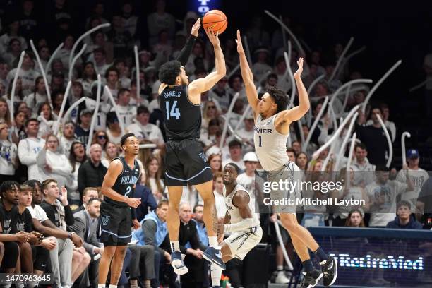 Caleb Daniels of the Villanova Wildcats takes a shot over Desmond Claude of the Xavier Musketeers during a college basketball game at the Cintas...