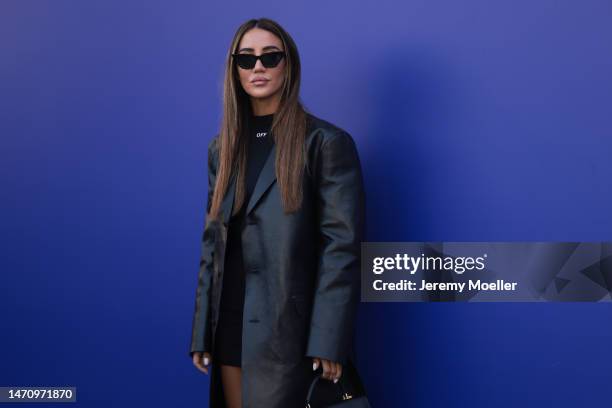 Tamara Kalinic seen wearing black vintage sunglasses, a black high halter-neck / short tube dress from Off-White, a black shiny leather belted long...