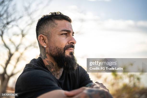 mature man contemplating outdoors - tatoeage stockfoto's en -beelden